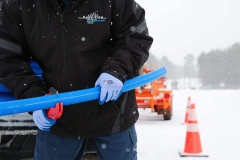 Hand holding a water line freeze protection system and cutting pliers on tailgate at job site