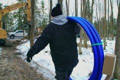 Contractor carrying water line freeze protection system over shoulder to job site