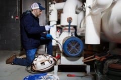 Contractor Installing External Self-Regulating Heating Cable System On Pipe