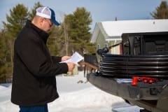 Contractor reading Manual for Heat-Line Freeze Protected Pipe System on Tailgate