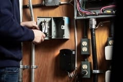 Contractor opening MilliAMP ELCI/GFCI on a indoor wall with other electrical appliances