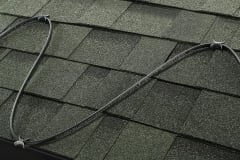 Paladin for Roof heating cable clipped onto green shingled roof