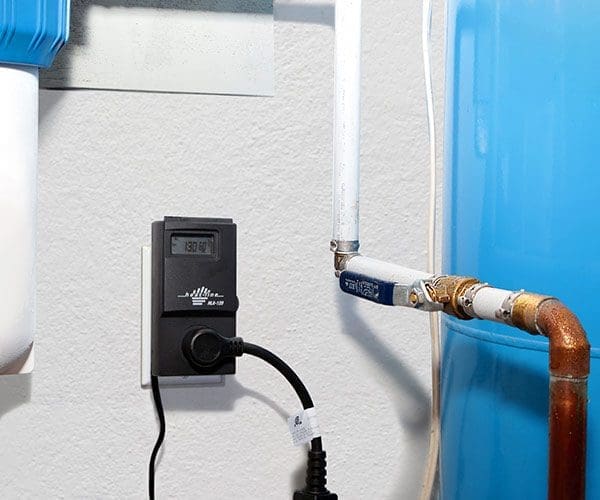 Thermostat and timer plugged into outlet on wall inside