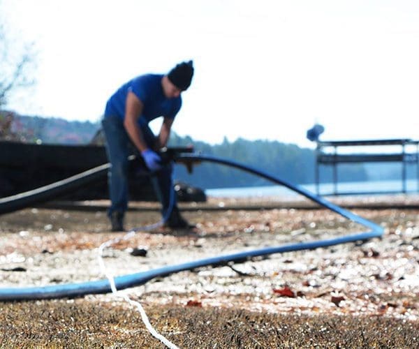 Contractor holding Polyethylene Pipe outdoors near a lake