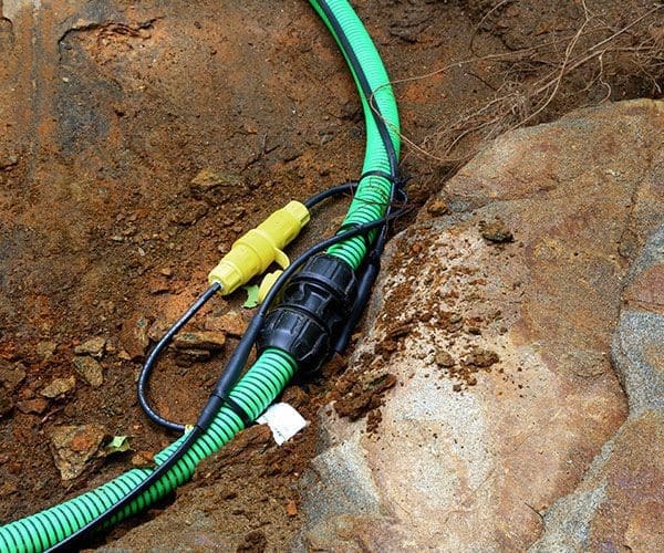 Inter-connecting, self-regulating heat trace system on pipe outdoors in dirt