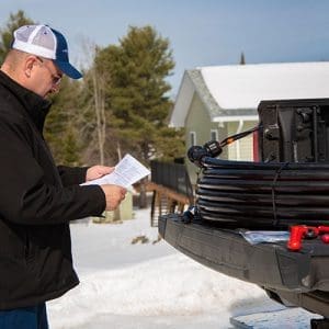 Heat-Line on Tailgate with Contractor reading self-regulating heat trace cable installation instructions