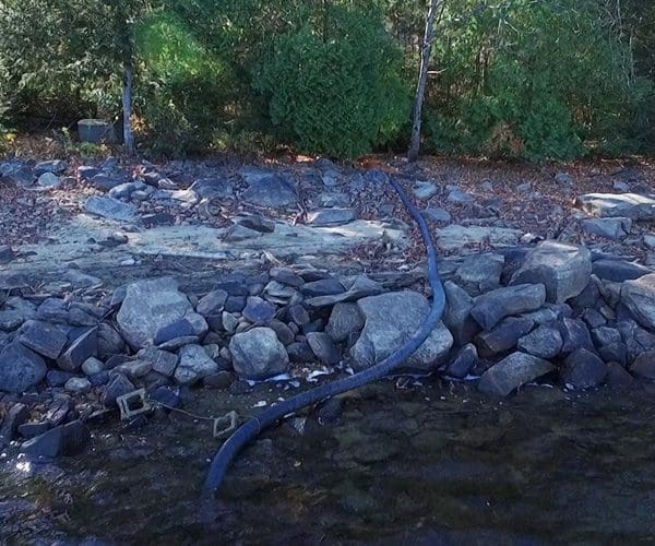 Water supply pipe on land to lake with stand at bottom of lake