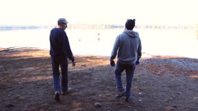 Two workers talking near lake